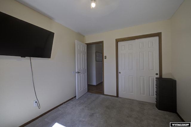 unfurnished bedroom featuring carpet floors, a closet, and baseboards