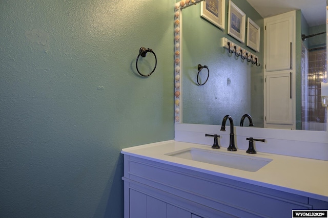 bathroom with vanity and a textured wall