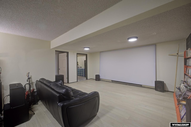 cinema room with a textured ceiling and light wood-style flooring