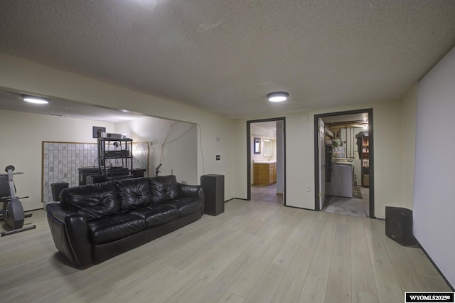 living area with a textured ceiling and light wood-style flooring