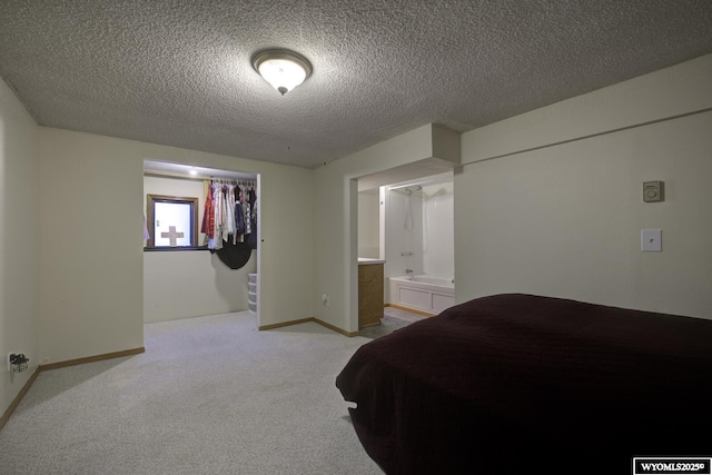 bedroom with baseboards, a textured ceiling, and light colored carpet