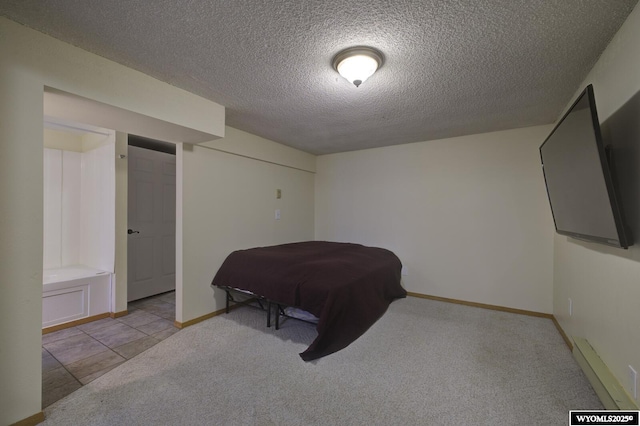 carpeted bedroom featuring a textured ceiling and baseboards