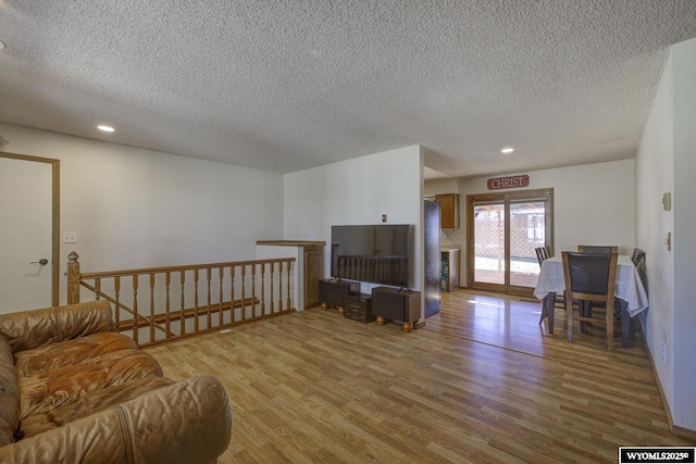 living room with a textured ceiling, wood finished floors, and recessed lighting