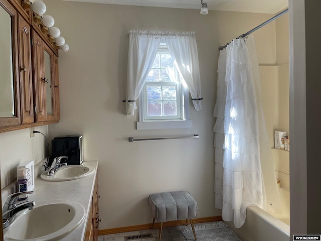 bathroom featuring visible vents, a sink, baseboards, and double vanity