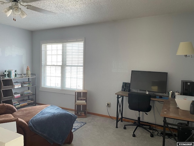 carpeted office with a textured ceiling, a ceiling fan, and baseboards