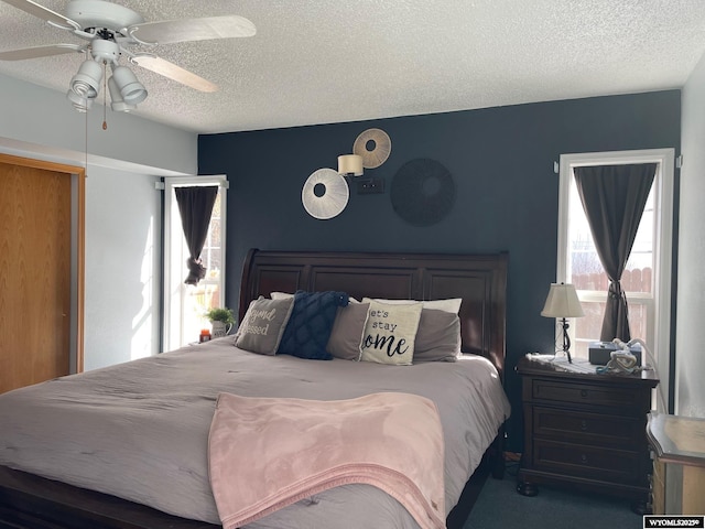 bedroom with a textured ceiling, ceiling fan, and carpet