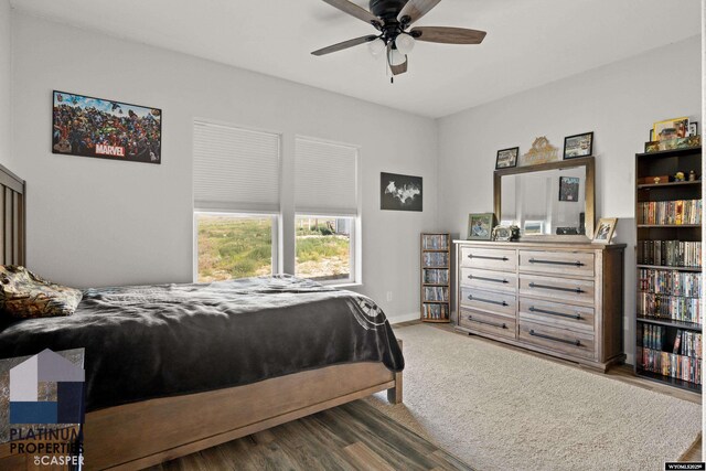 bedroom featuring ceiling fan, baseboards, and wood finished floors