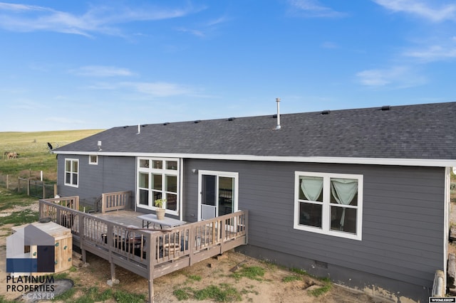 rear view of house with a deck, a shingled roof, and crawl space