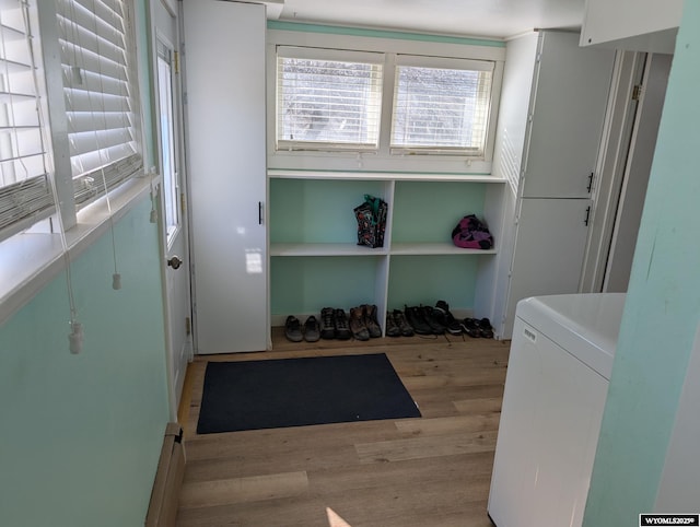 exercise room with washer / dryer and light wood-style floors