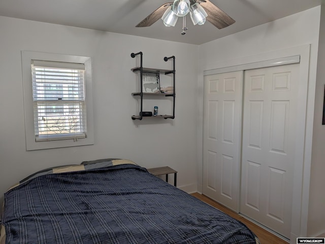 bedroom featuring a ceiling fan, a closet, and wood finished floors