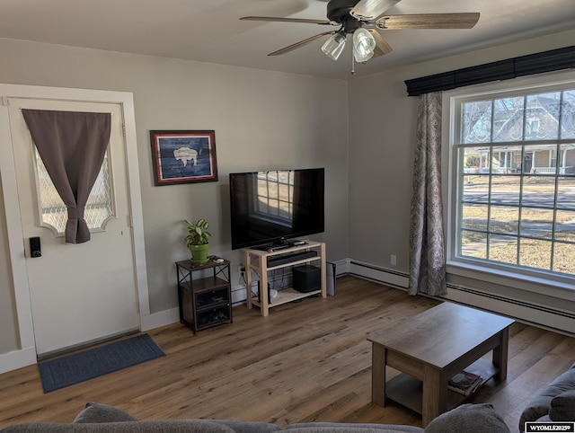 living room featuring ceiling fan, baseboards, and wood finished floors