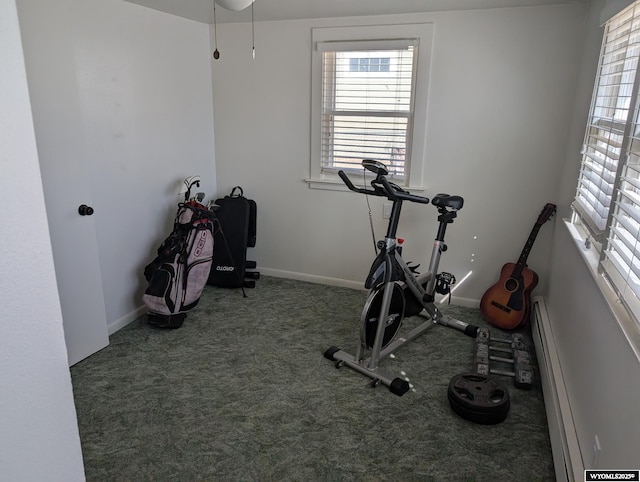 workout area with a baseboard heating unit, carpet, and baseboards