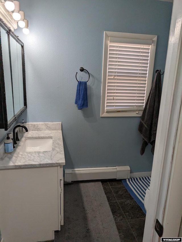 bathroom featuring baseboard heating, vanity, and baseboards