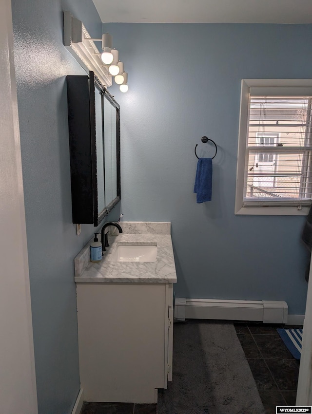 bathroom featuring baseboards, a baseboard heating unit, and vanity