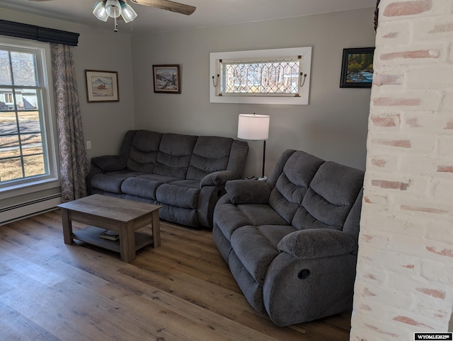 living area with a healthy amount of sunlight, ceiling fan, and wood finished floors