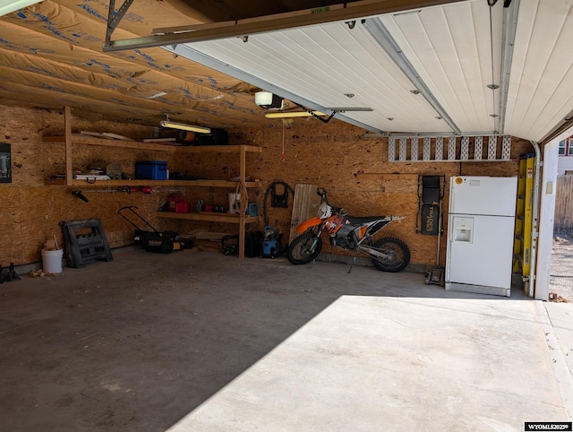 garage featuring a garage door opener and freestanding refrigerator