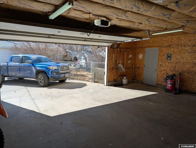 garage with a garage door opener and electric panel