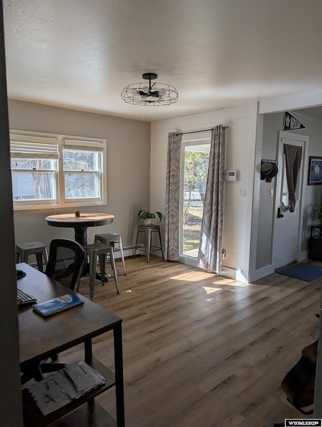 dining space with a textured ceiling and wood finished floors