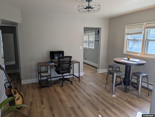 office area featuring baseboards, baseboard heating, and wood finished floors