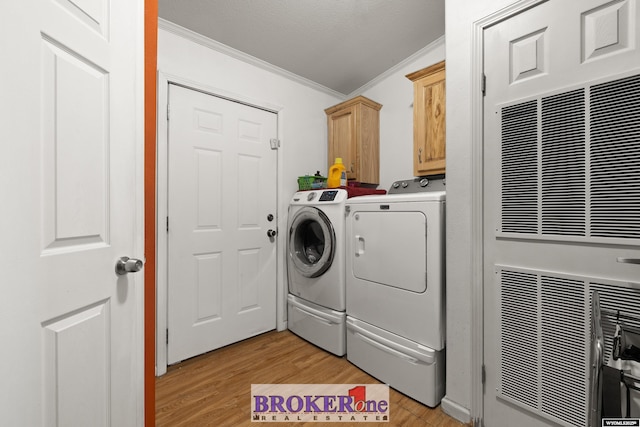 washroom with washer and clothes dryer, light wood-style flooring, cabinet space, and ornamental molding