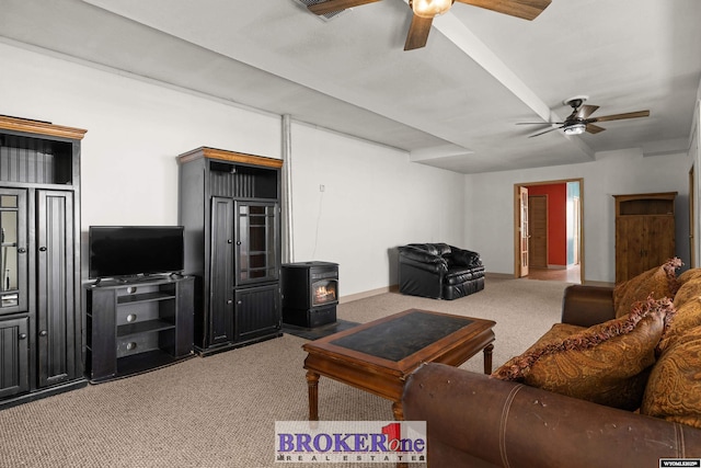 carpeted living area featuring a wood stove and a ceiling fan