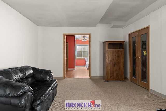 living room with baseboards and light colored carpet