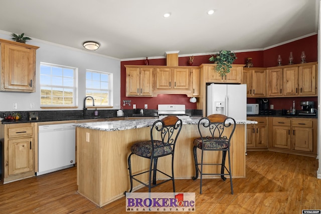 kitchen featuring a center island, crown molding, light wood-style floors, white appliances, and a sink