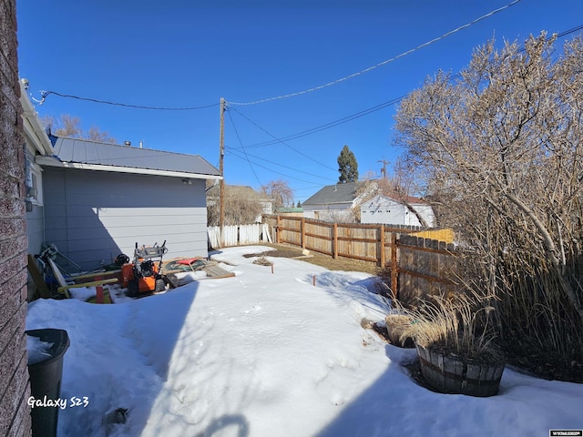 yard layered in snow with a fenced backyard