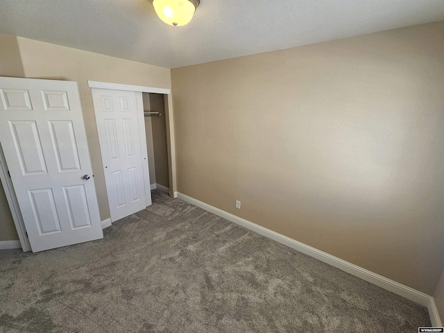 unfurnished bedroom featuring a closet, carpet flooring, and baseboards