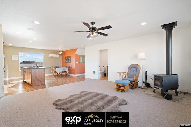 living area with light carpet, a wall unit AC, ceiling fan, a wood stove, and recessed lighting