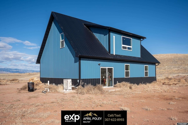 rear view of house with metal roof and ac unit