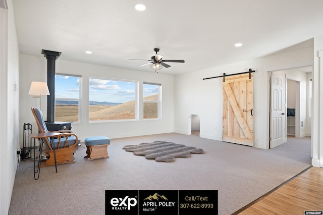 sitting room with carpet floors, recessed lighting, ceiling fan, and a barn door