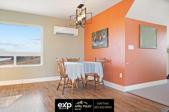 dining room featuring an AC wall unit, an inviting chandelier, wood finished floors, and baseboards