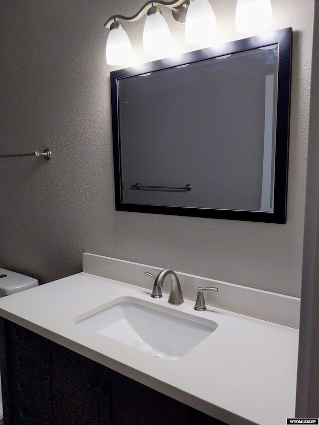 bathroom featuring a textured wall and vanity