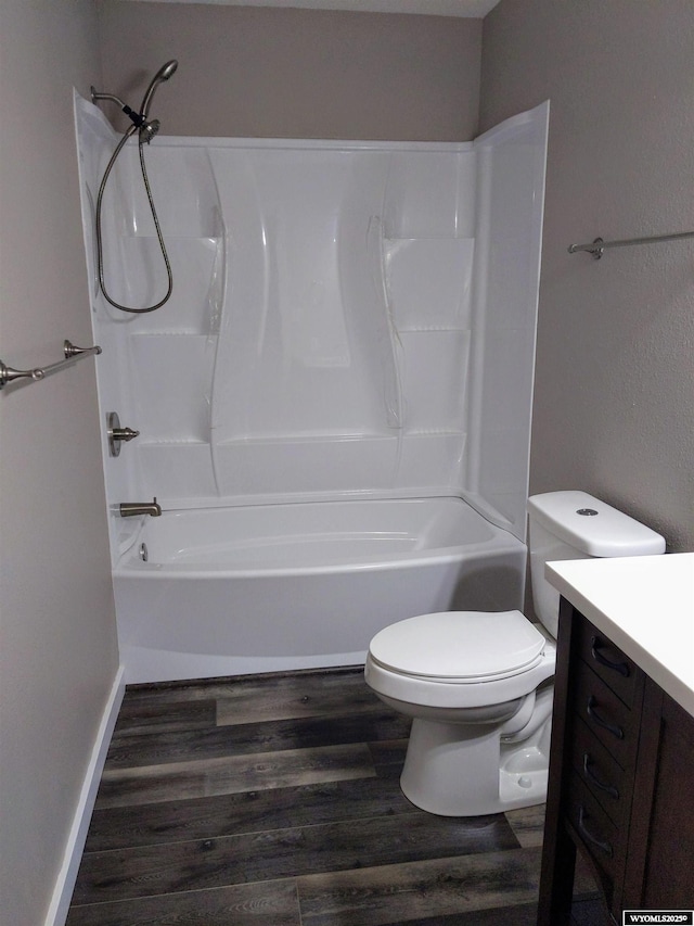 bathroom with toilet, shower / bathing tub combination, wood finished floors, and vanity