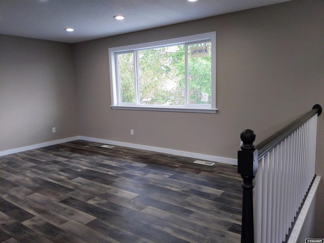 unfurnished room featuring visible vents, recessed lighting, baseboards, and dark wood-style flooring