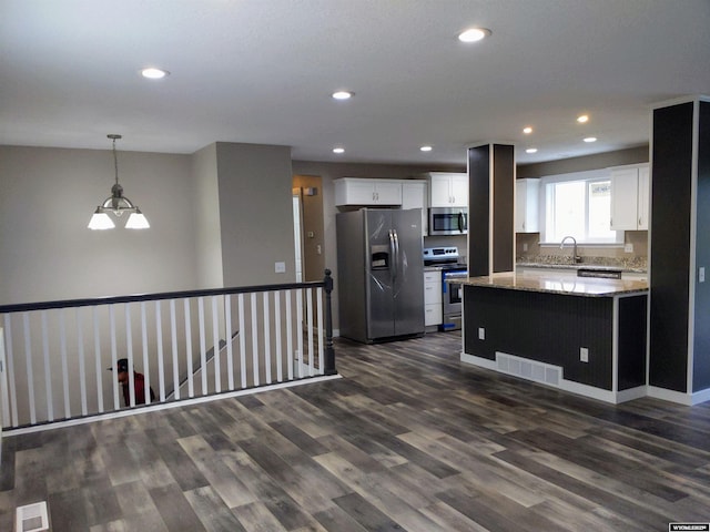 kitchen featuring appliances with stainless steel finishes, visible vents, and white cabinets