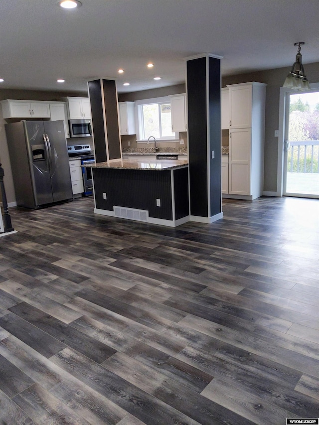 kitchen with white cabinets, open floor plan, dark wood-style flooring, stainless steel appliances, and recessed lighting