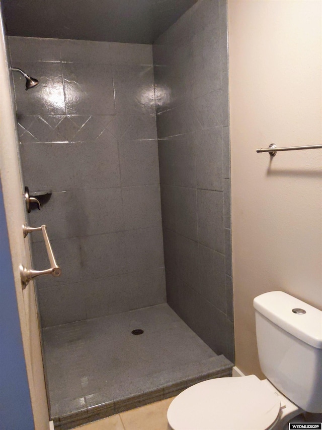 full bath featuring tile patterned flooring, a tile shower, and toilet