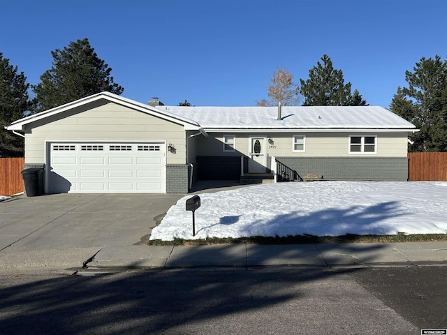 view of front of property featuring a garage, brick siding, concrete driveway, and fence