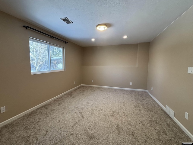 carpeted spare room with recessed lighting, baseboards, visible vents, and a textured ceiling