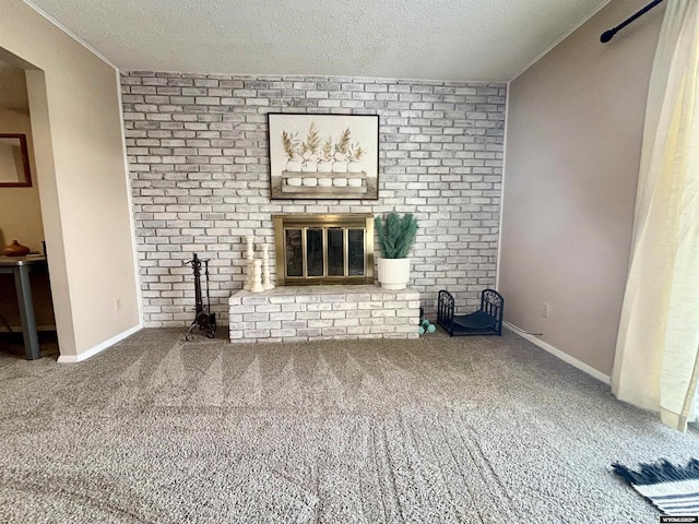 unfurnished living room with carpet flooring, a brick fireplace, a textured ceiling, and baseboards