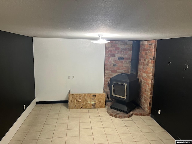 living area with light tile patterned floors, a textured ceiling, and a wood stove