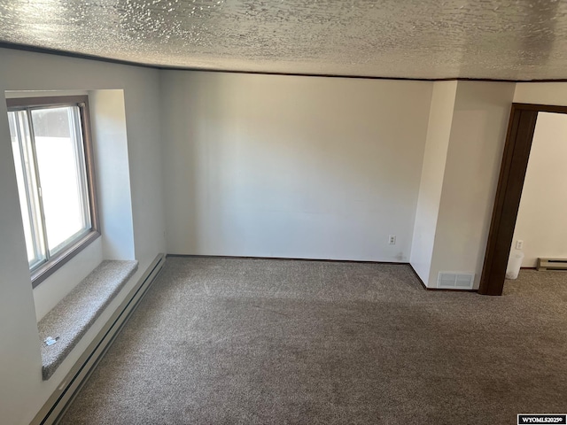 carpeted empty room with a baseboard heating unit, a textured ceiling, and visible vents