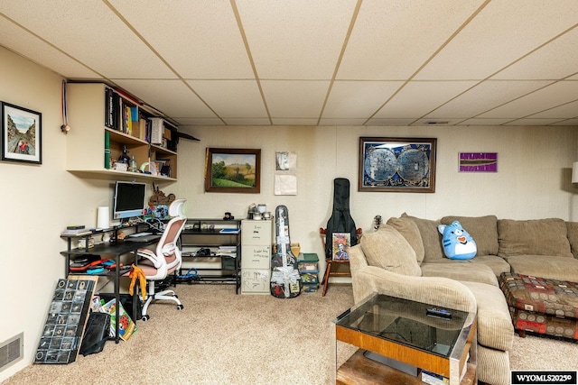 carpeted office with a paneled ceiling