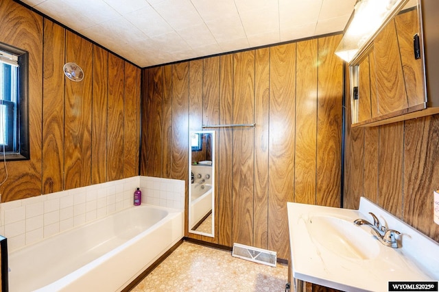 bathroom featuring vanity, a garden tub, wooden walls, and visible vents