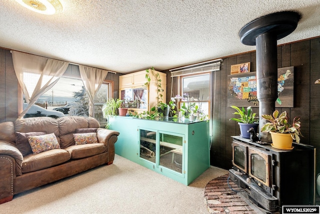 living room with carpet floors, a textured ceiling, and a wood stove