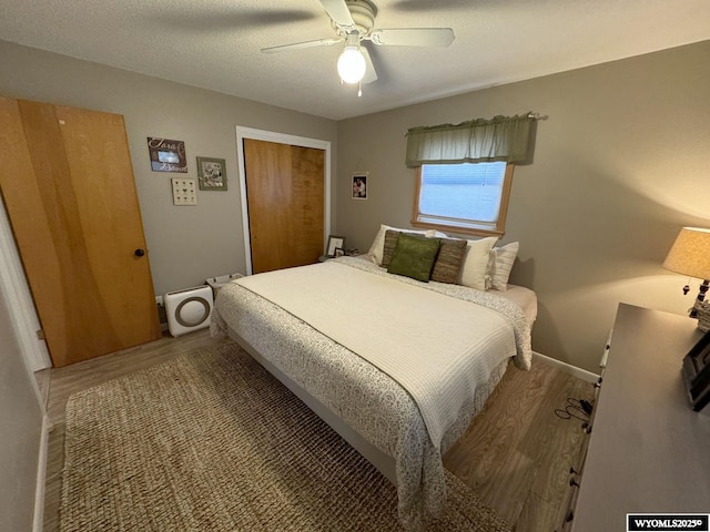 bedroom featuring a closet, a textured ceiling, wood finished floors, and a ceiling fan