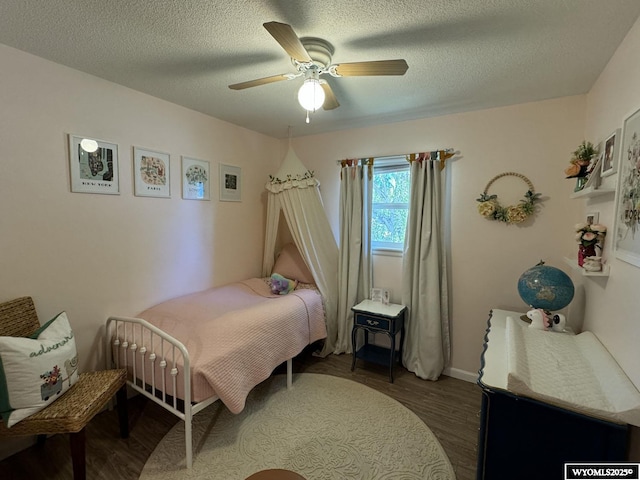 bedroom featuring ceiling fan, a textured ceiling, and wood finished floors