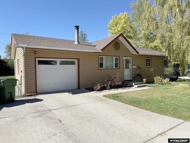 single story home with concrete driveway, an attached garage, a front yard, and a shingled roof